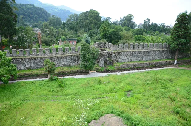 Gonio Fortress inner courtyard — battlements, green lawn and Adjara mountains in the background