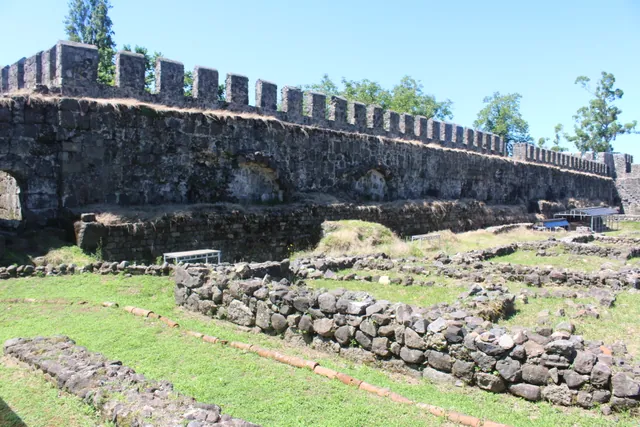 Gonio Fortress Georgia — interior view of the main battlement wall with ancient foundation ruins in the foreground