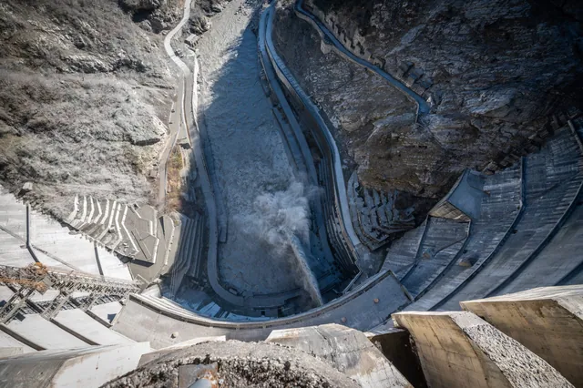 View straight down from the crest of Inguri Dam into the gorge — 271 metres, water discharge