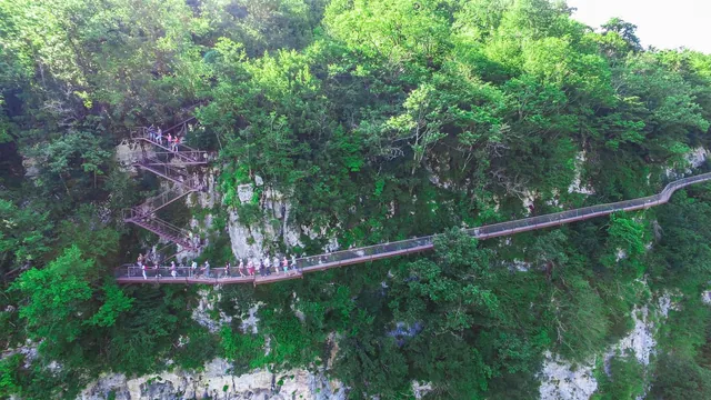 A metal walkway and staircase on the wall of the Okatse gorge, seen from the side