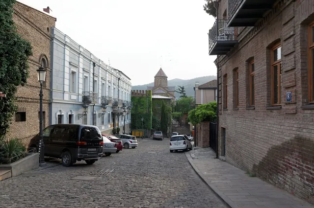 A cobbled street of old Tbilisi with a view of a church bell tower
