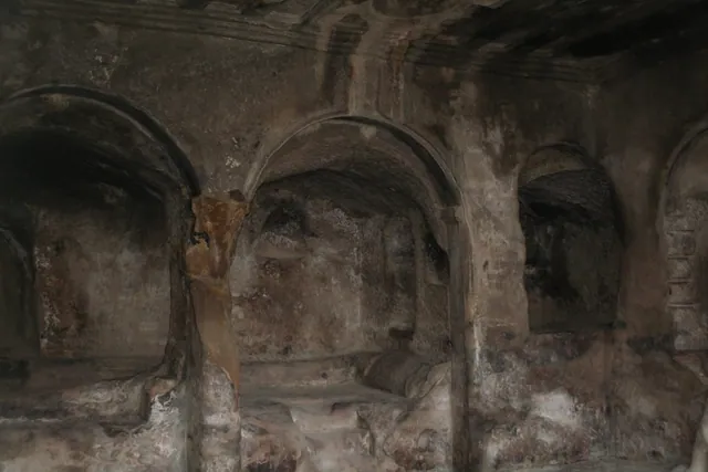 A hall with stone arches and a carved ceiling in Uplistsikhe