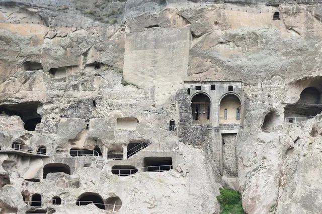 Arches and the bell tower of Vardzia with paths along the cliff